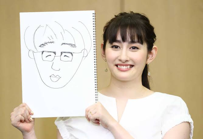 夫の似顔絵を掲げる早見あかりさん